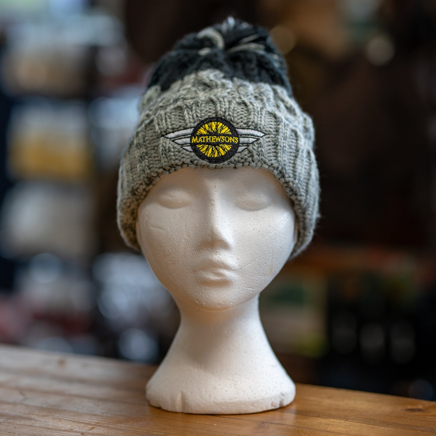 Knitted beanie with a logo on a mannequin head against a blurred background