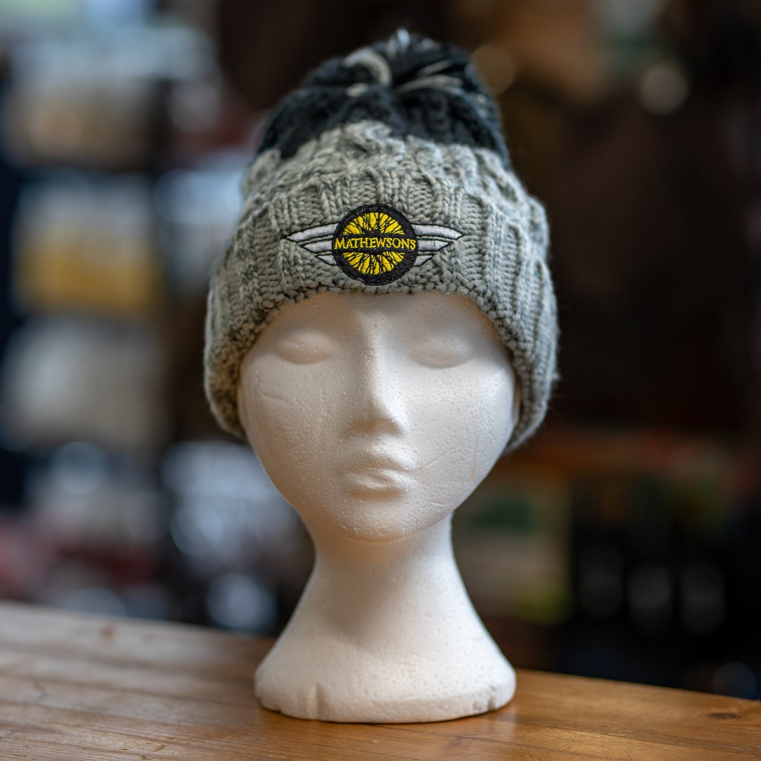 Knitted beanie with a logo on a mannequin head against a blurred background
